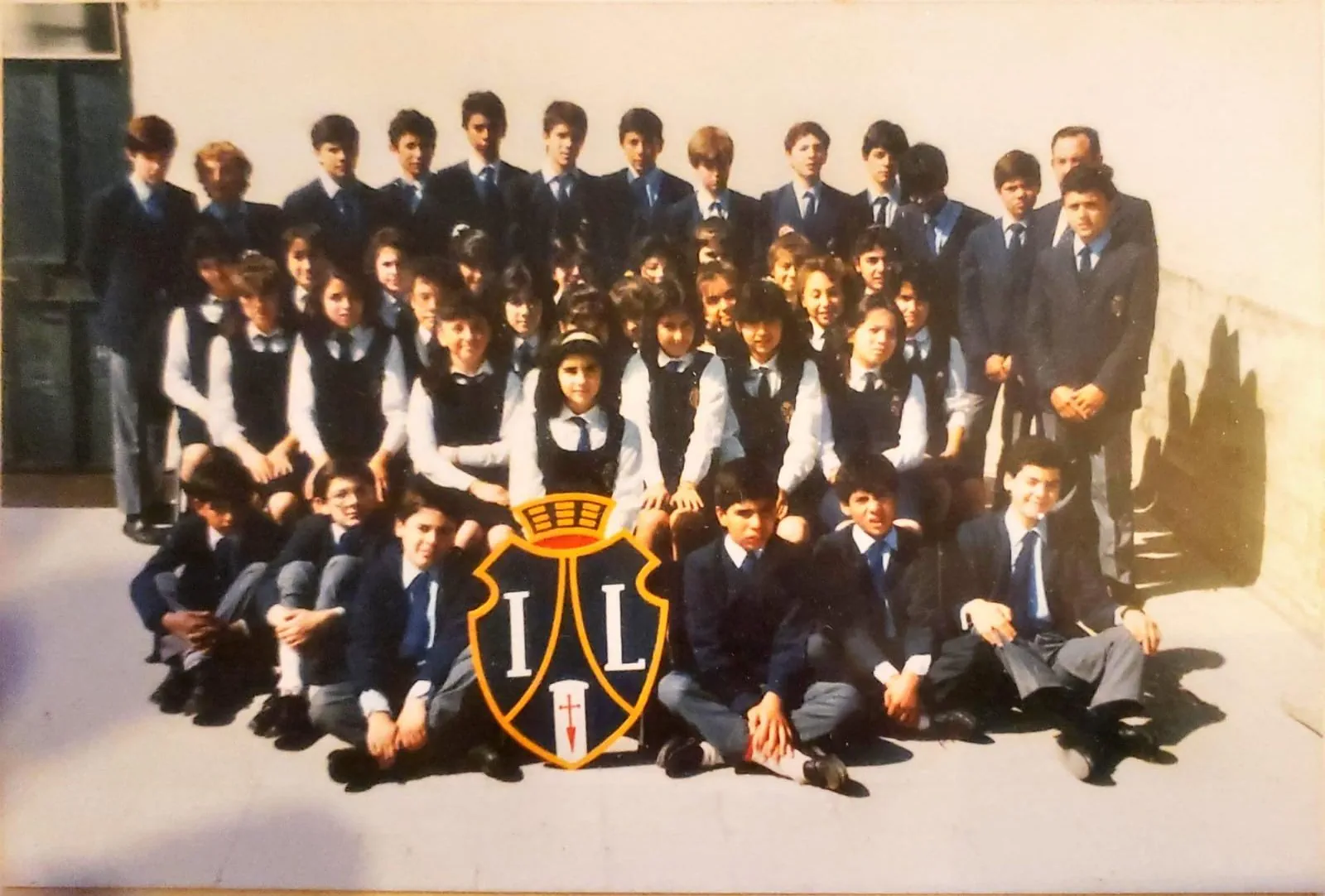 El curso en 1987, en 7mo básico, posando con el escudo del Instituto Linares